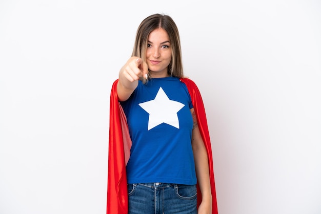 Young Romanian woman isolated on white background in superhero costume and pointing to the front