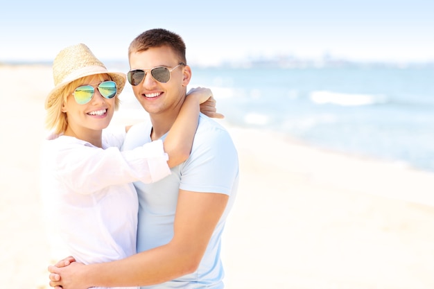 young romantic couple hugging at the beach and copy space