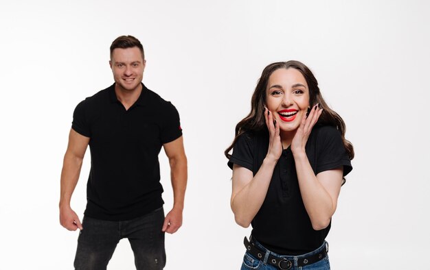 Young romantic couple posing on white Cheerful emotional couple at isolated background