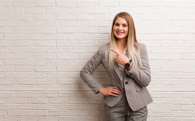 Photo young russian business woman smiling and pointing to the side