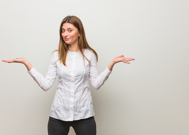 Young russian girl doubting and shrugging shoulders