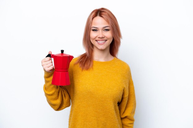 Young Russian girl holding coffee pot isolated on white background smiling a lot