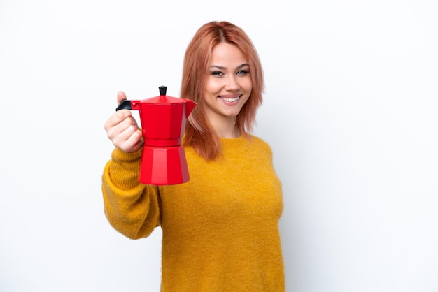 Young Russian girl holding coffee pot isolated on white background with happy expression