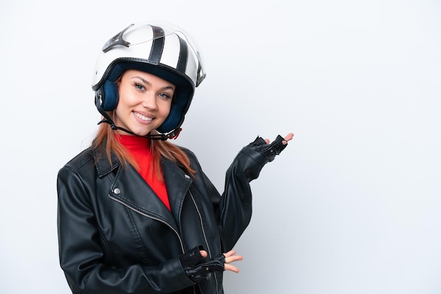 Young Russian girl with a motorcycle helmet isolated on white background extending hands to the side for inviting to come