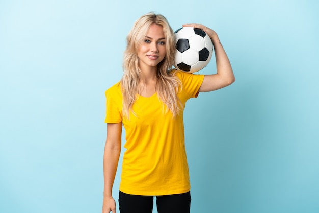 Photo young russian woman isolated on blue background with soccer ball