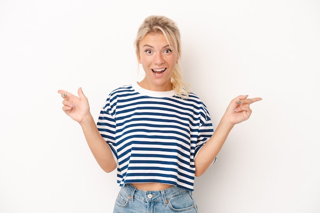 Young Russian woman isolated on white background pointing to different copy spaces, choosing one of them, showing with finger.