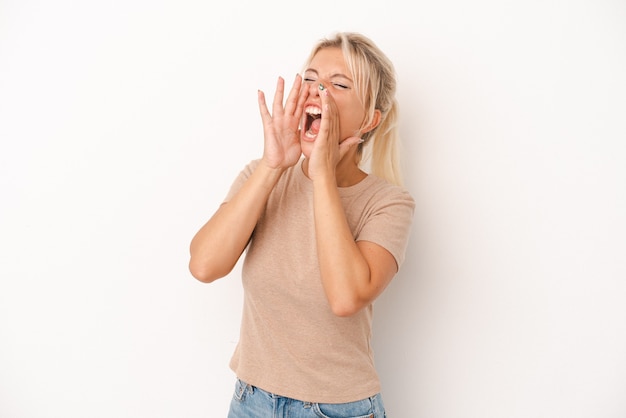 Young Russian woman isolated on white background shouting excited to front.