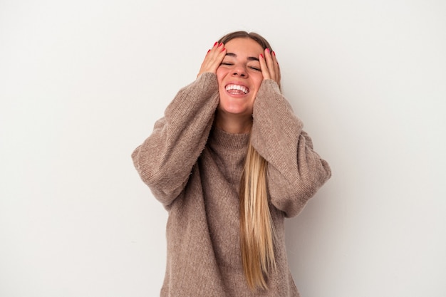 Young Russian woman isolated on white background shrugs shoulders and open eyes confused.