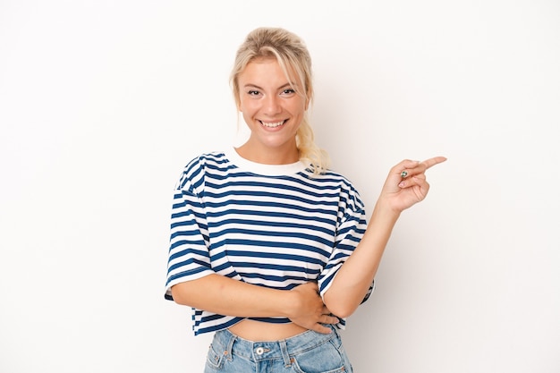 Young Russian woman isolated on white background smiling cheerfully pointing with forefinger away.