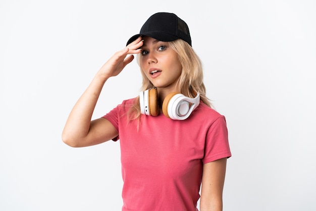 Young Russian woman listening music isolated on white doing surprise gesture while looking to the side