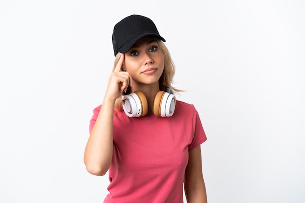 Young Russian woman listening music isolated on white wall thinking an idea