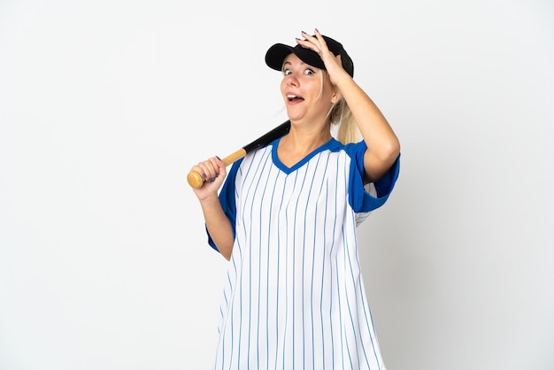 Young Russian woman playing baseball isolated on white wall doing surprise gesture while looking to the side