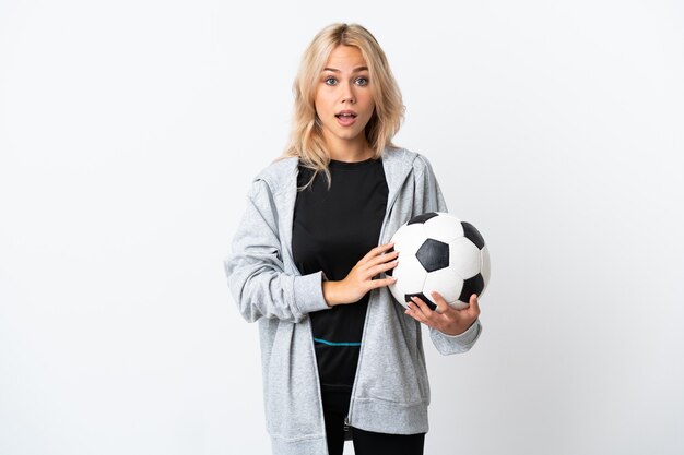 Young Russian woman playing football isolated on white background with surprise facial expression