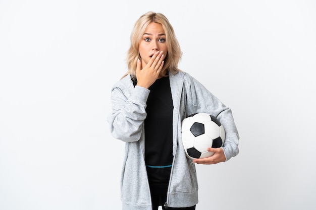 Young Russian woman playing football isolated on white wall happy and smiling covering mouth with hand