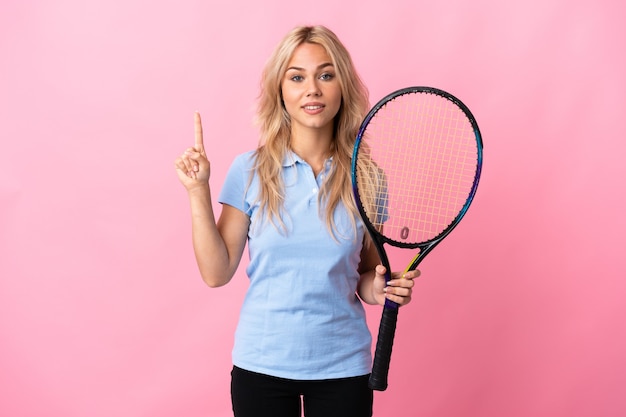 Photo young russian woman playing tennis isolated on purple wall showing and lifting a finger in sign of the best