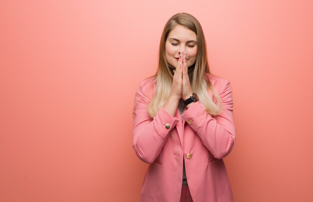 Young russian woman wearing pajama praying very happy and confident