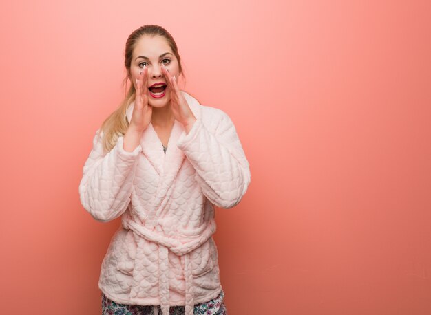 Young russian woman wearing pajama shouting something happy to the front