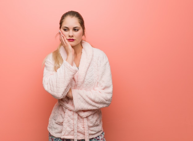 Young russian woman wearing pajama tired and very sleepy