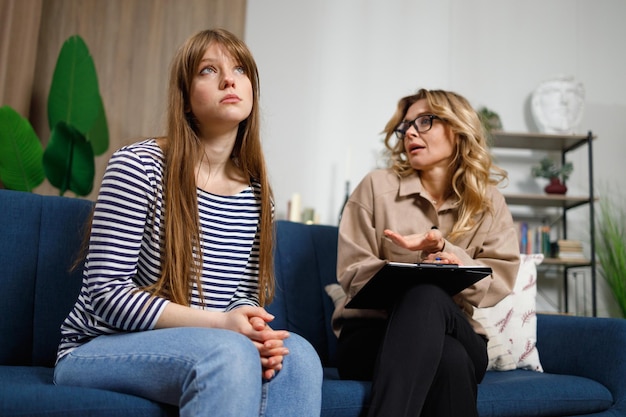 Young sad woman listens to the advice of a psychologist