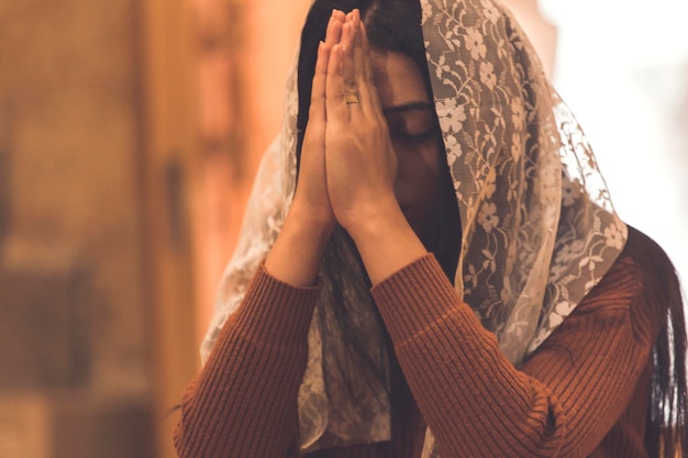 Young sad woman praying in church