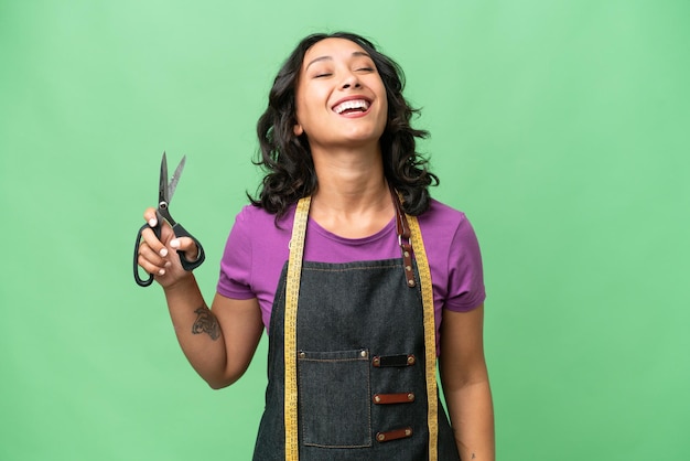 Young seamstress argentinian woman over isolated background laughing