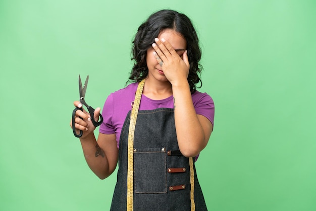 Young seamstress argentinian woman over isolated background with tired and sick expression