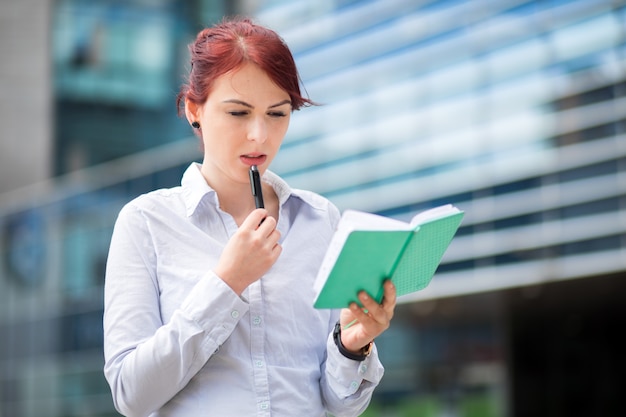 Young secretary reading her agenda outdoor