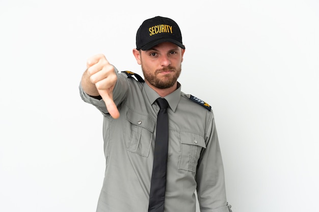 Young security Brazilian man isolated on white background showing thumb down with negative expression