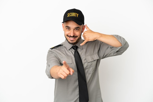 Young security  caucasian man isolated on white background making phone gesture and pointing front