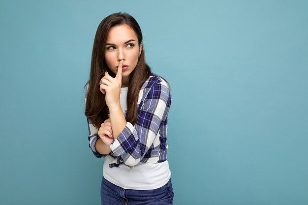 Young serious angry beautiful brunet woman with sincere emotions wearing trendy check shirt standing