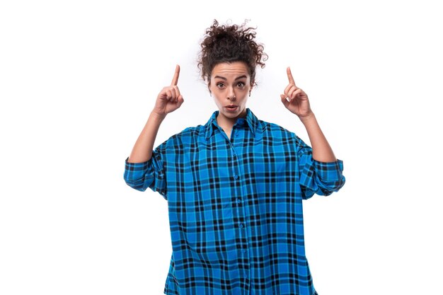 Young serious european woman with curly hair showing thumbs up