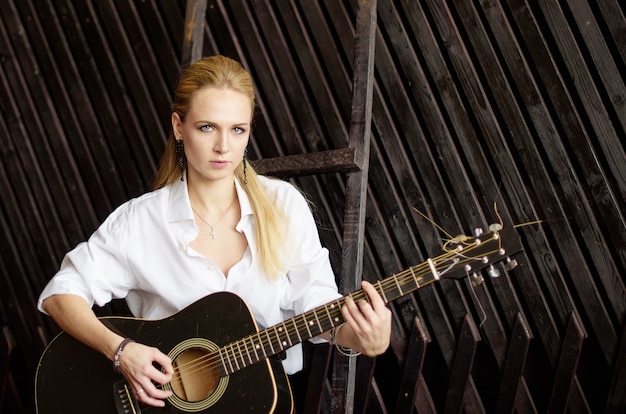 young sexy blonde girl playing guitar