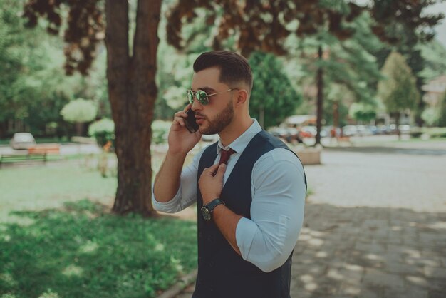 A young sexy businessman in a suit talking on smartphone