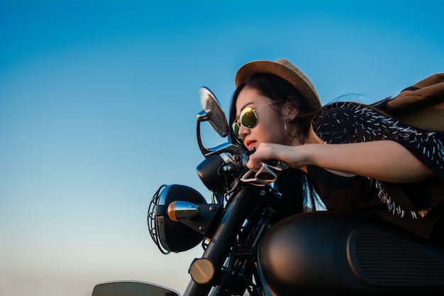 Young sexy woman on a motorcycle in nature on the sunset. Travel Concept.