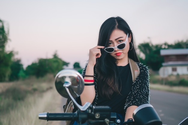 Young sexy woman on a motorcycle in nature on the sunset. Travel Concept.