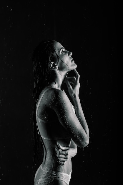 Young sexy woman in white lingerie. Water studio photo.