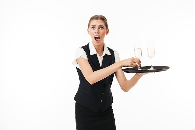 Young shocked waitress in uniform amazedly 