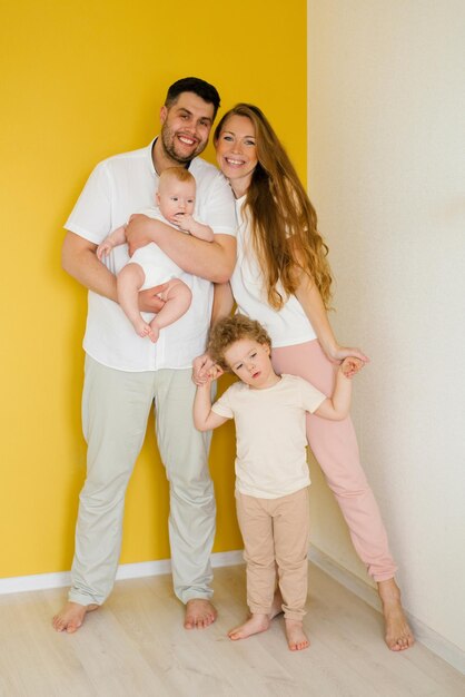 Young sincere family where a happy father and mother hold their lovely children in their arms Family photo shoot in the studio