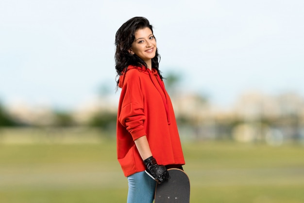 Young skater woman with red sweatshirt