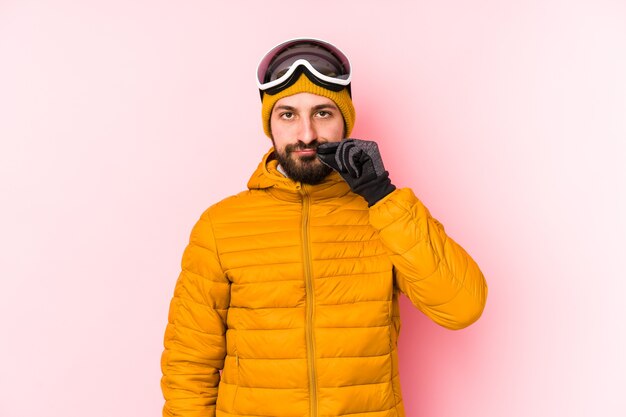 Photo young skier man isolated with fingers on lips keeping a secret.