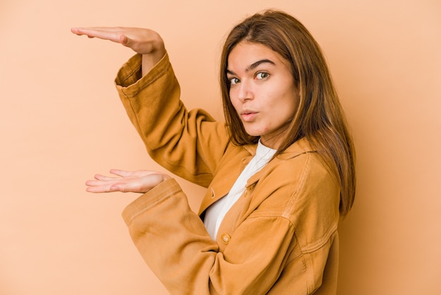 Young skinny teenager girl holding something with both hands, product presentation