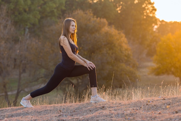 A young slim athletic girl in sportswear with snakeskin prints performs a set of exercises