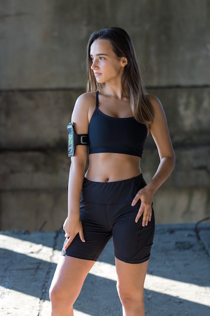 A young slim athletic girl in sportswear with snakeskin prints performs a set of exercises