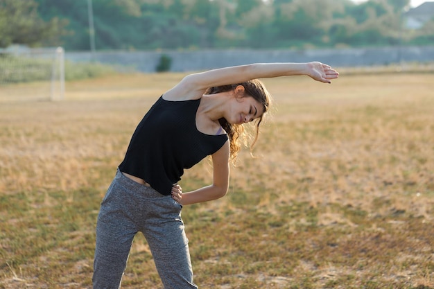 A young slim athletic girl in sportswear with snakeskin prints performs a set of exercises