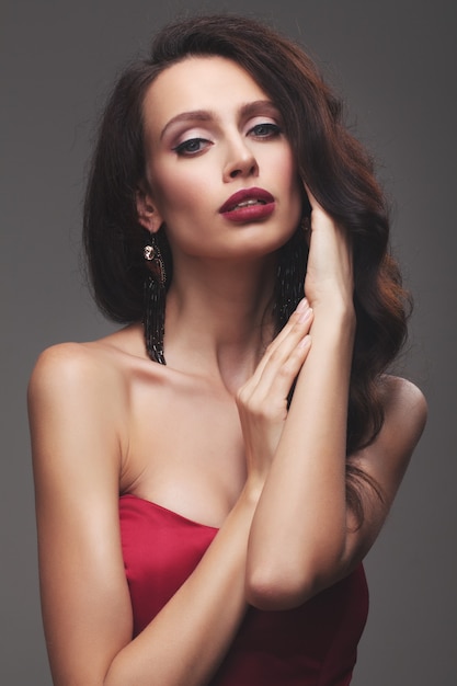 Young slim girl in a red dress. luxury fashion in the studio