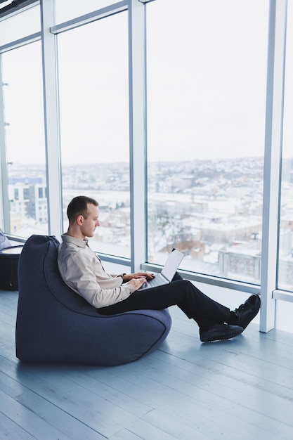 Young smart male businessman is sitting in the office and working on a project related to public cyber technology Businessmen with laptop trying to meet deadlines in external marketing