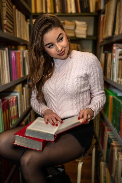 A young smart student is studying useful and interesting in a beautiful old library