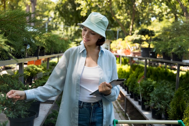 Young smiley woman working in a greenhouse