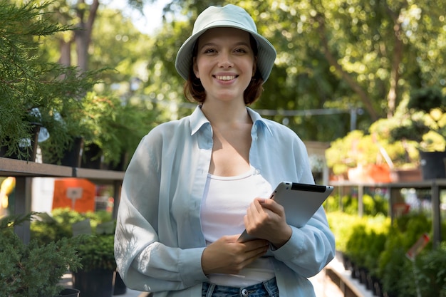 Young smiley woman working in a greenhouse