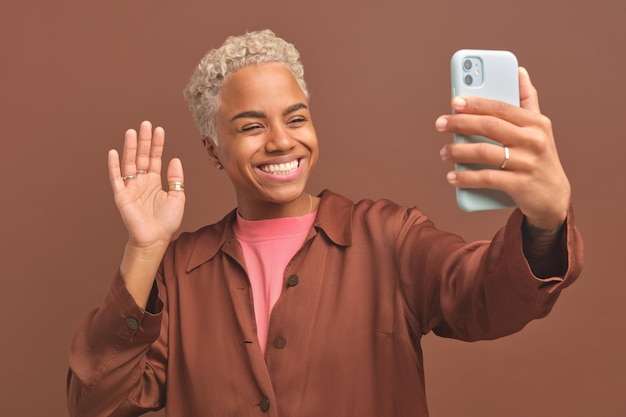 Young smiling african american woman waving talking on video call on phone